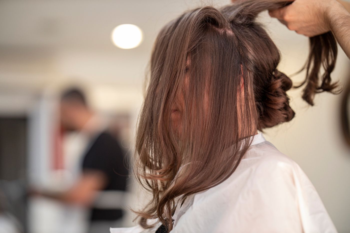 Stylist sectioning long brown hair